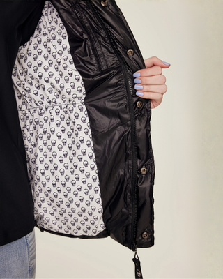 Detail shot of the interior lining of the black vest, featuring a unique white fabric with small black skull prints.