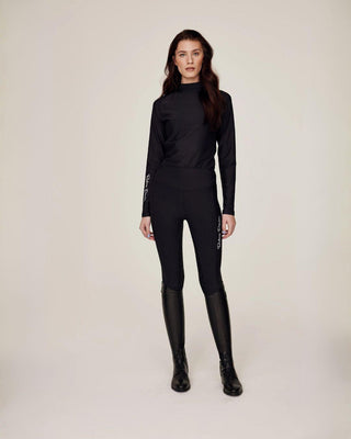 Full body front view of a model wearing the matching black compression riding set.