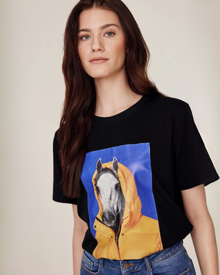 Three-quarter front view of a model showcasing the black horse print tee for riders.