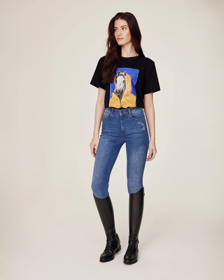 Full body shot of a model styling the black horse print t-shirt with original denim riding breeches.