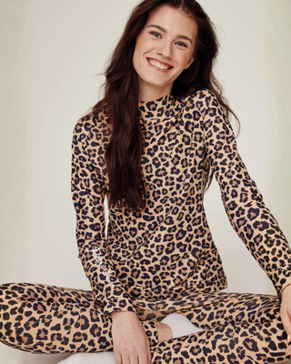 Model with a wide smile sitting down, showcasing the comfort and full silicone seat grip of the leopard riding set.