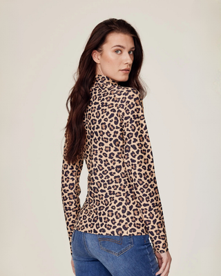 Back view of a model looking over her shoulder while wearing the leopard print equestrian top.