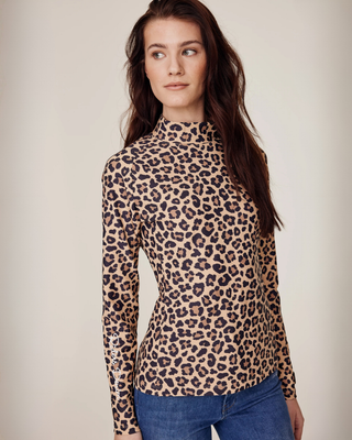 Angled front view of a model wearing the leopard print riding top with a technical performance fit.