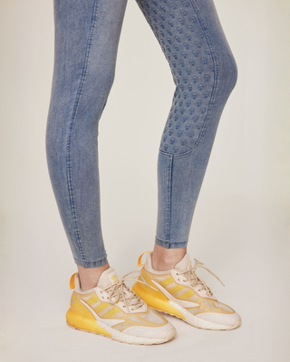 Detailed shot of the ankle cuffs and the skull-patterned silicone seat on the light blue jeans breeches.