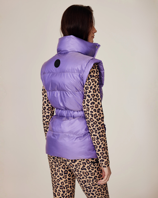 Angled back view of a model in the lilac puffer vest and leo riding set, showing the silhouette from behind.
