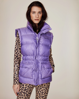 Model wearing the lilac riding puffer vest zipped up, styled with matching leopard print breeches.