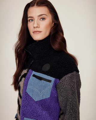 Close-up portrait highlighting the chest pocket detail, denim accents, and Riders Denim logo on the lilac teddy fabric.