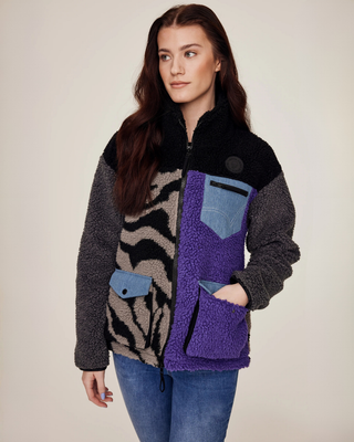Model looking to the side with a hand in the pocket, showcasing the functional design of the lilac and zebra teddy jacket.