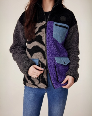 Close-up detail of the functional two-way zipper on the lilac and zebra teddy jacket, designed for comfort in the saddle.