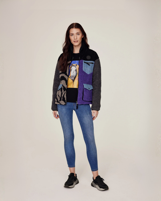 Full body shot of a model wearing an unzipped lilac and zebra jacket over a black t-shirt and OG denim breeches.