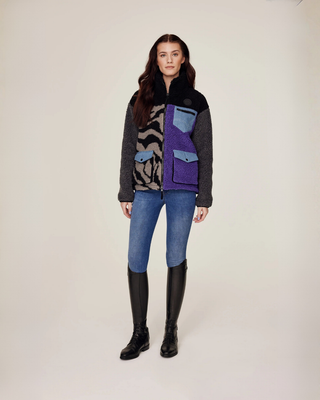 Full body front view of a model wearing the zipped lilac and zebra teddy jacket for a cozy equestrian look.