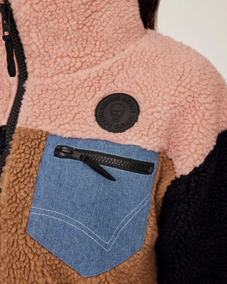 Detailed shot of the chest pocket with a zipper and the signature Riders Denim logo on the pink panel.