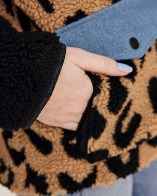 Close-up of the front pockets on the teddy jacket, highlighting the functional design and denim fabric accents.