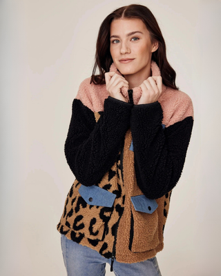 Fashion pose of a model showcasing the unique beige, leopard, and pink color-block design of the teddy jacket.