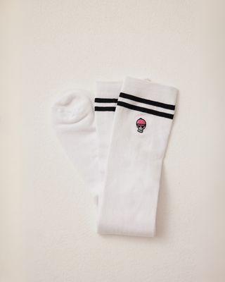 Folded white riding socks showcasing the cuff details, stripes, and signature skull embroidery.