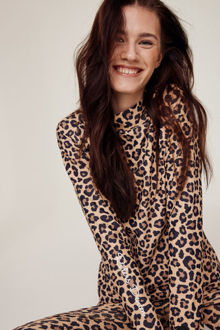 Laughing model sitting down wearing the complete leopard print riding set from Riders Denim.